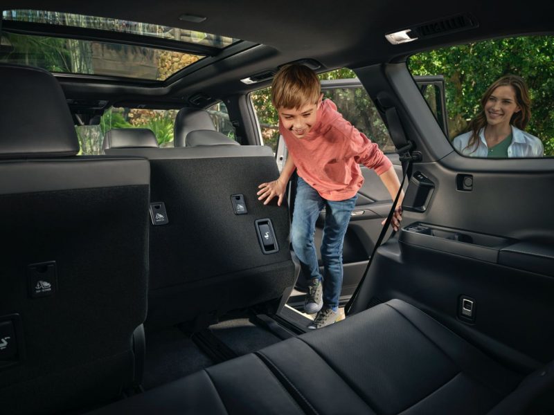 Kid jumping into the back seat of a Lexus
