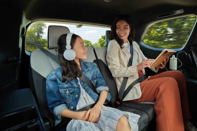 Passengers in the backseat of a luxury SUV, enjoying their drive.