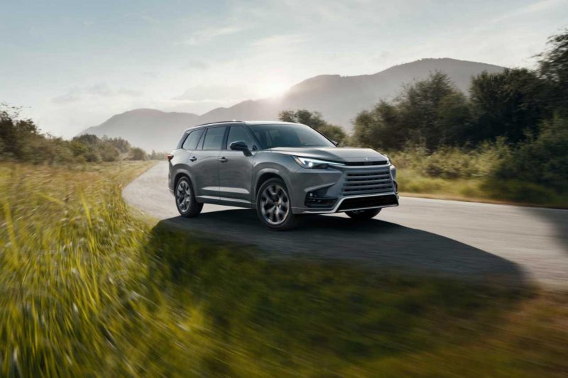 A 2024 Lexus TX luxury SUV vehicle drives down a country road.
