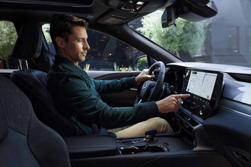 This image shows a Caucasian man sits in the front seat of a Lexus SUV.