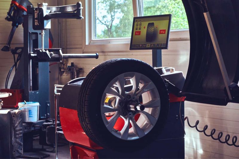 A tire on a computerized spin-balancing machine for checking the balance and alignment of a car tire.