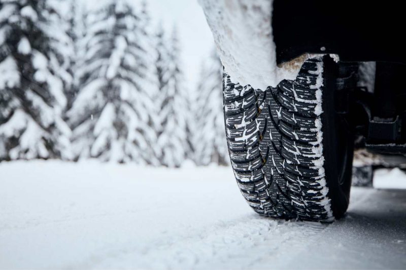 Winter tires on a vehicle on a snowy road.