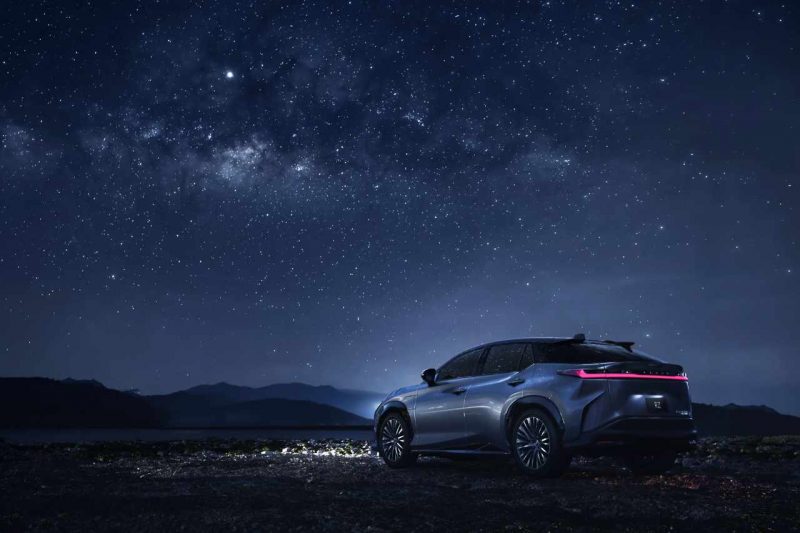 The Lexus 2024 RZ 450e vehicle underneath a big starry sky at night.