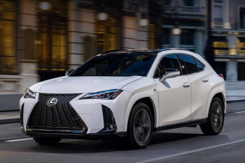 A white Lexus 2025 UX 300h is parked in the middle of a city street.
